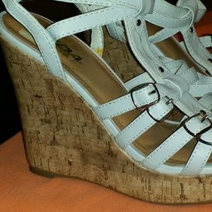 A pair of white and tan colored clog sandals